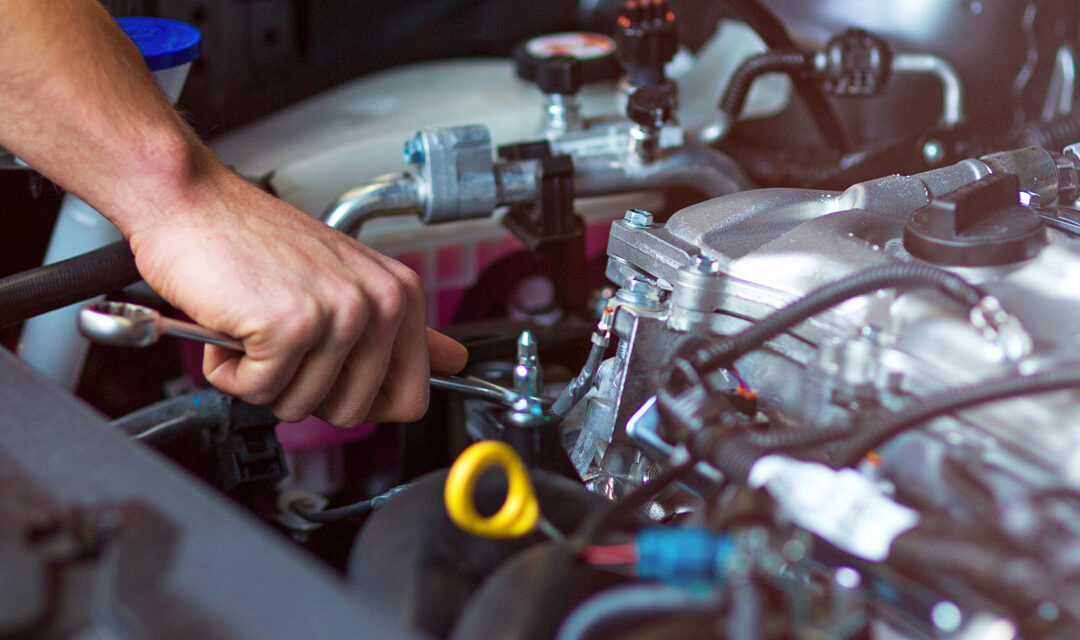 mechanic tightening a bolt on engine
