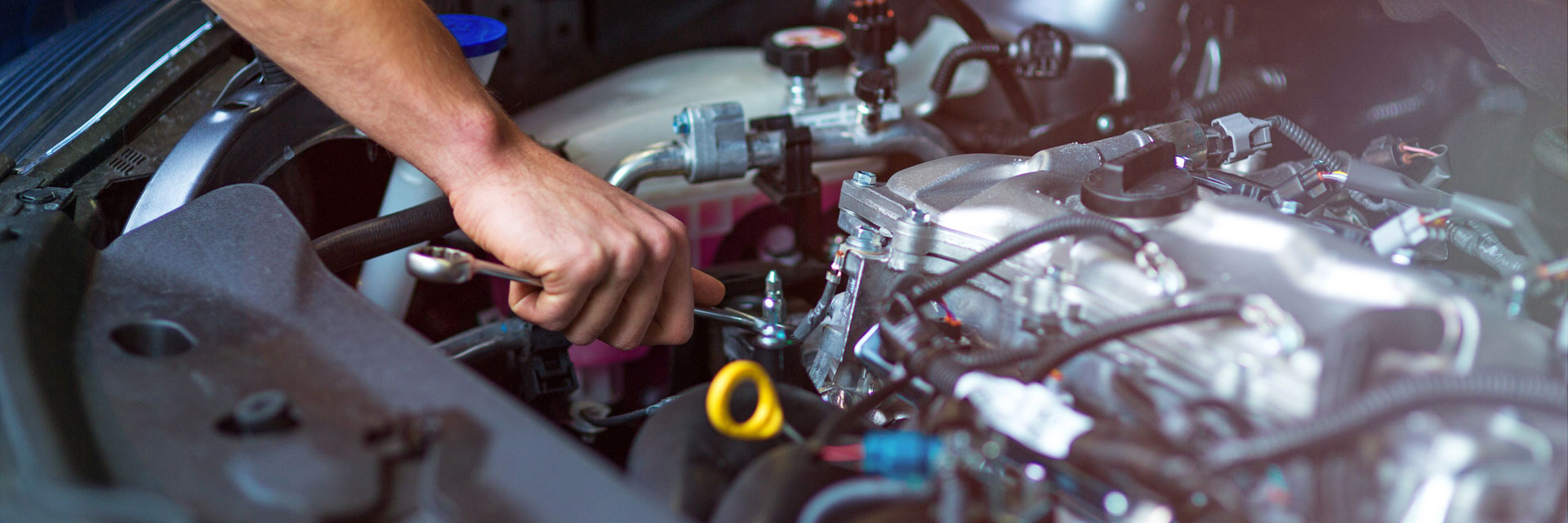 mechanic tightening a bolt on engine